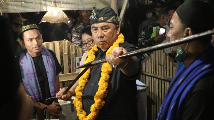 Bupati Jembrana I Nengah Tamba saat mencoba menghunus Pedang Daeng milik Raja Jembrana I Gusti Ngurag Pancoran