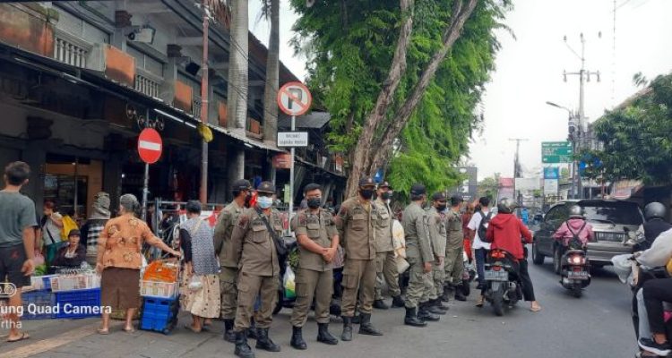 Ket foto : Tim Pengawasan Desa Dauh Puri Kelod saat melaksanakan pengaturan bagi Pedagang Pasar Tumpah dan Parkir yang menggunakan badan Jalan di Kawasan Pasar Sanglah, Denpasar, Jumat (21/10).