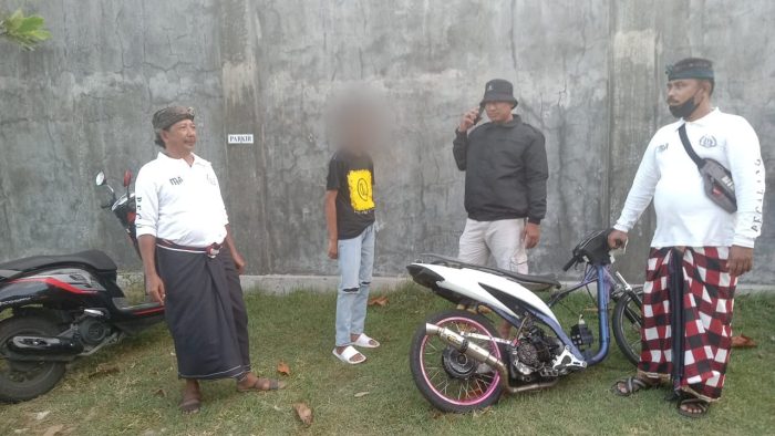 Ket poto: Salah satu pelaku trek-trekan diamankan petugas kepolisian bersama Pecalang setempat