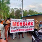 Ket poto: Warga Desa Tegal Badeng Barat melakukan aksi demo membentangkan spanduk penolakan pabrik Limbah B3