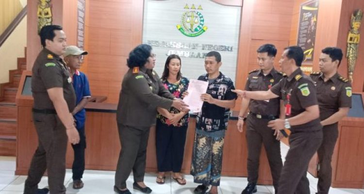 Ket poto: Kepala Kejaksaan Negeri Jembrana, Dr. Salomina Meyke Saliama menyerahkan berkas penghentian penuntutan kepada terdakwa