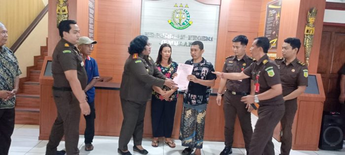 Ket poto: Kepala Kejaksaan Negeri Jembrana, Dr. Salomina Meyke Saliama menyerahkan berkas penghentian penuntutan kepada terdakwa