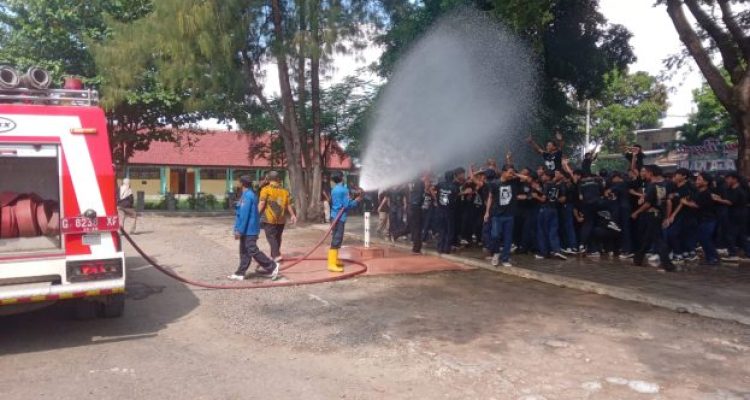 Ket poto: Damkar Tegal semprotkan air ke anak sekolah saat perpisahan kelulusan