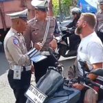Ket Poto: Petugas kepolisian saat memberhentikan warga negara asing saat mengendarai motor tanpa helm