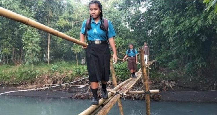 Ket poto: Anak-anak sekolah saat menyebrangi jembatan bambu di Kelurahan Pendem