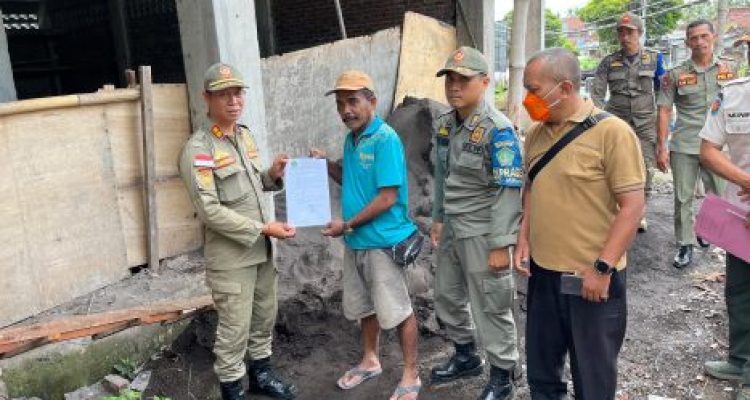 Ket poto: Petugas Satpol PP Jembrana memberikan surat teguran pertama kepada penanggung jawab bangunan