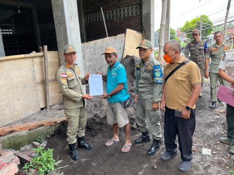 Ket poto: Petugas Satpol PP Jembrana memberikan surat teguran pertama kepada penanggung jawab bangunan