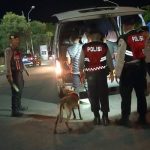 Ket poto: Petugas kepolisian menuntun anjing pelacak saat mengecek barang bawaan di kendaraan