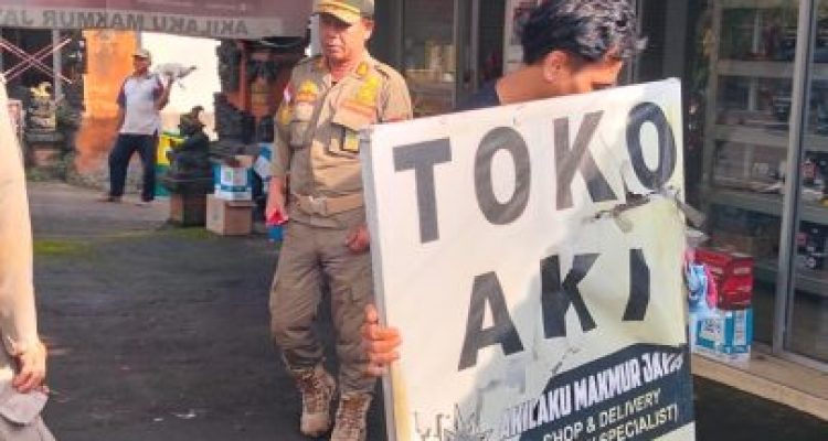 Ket poto: Petugas Satpol PP menggusur papan nama yang berada di trotoar jalan