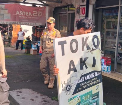 Ket poto: Petugas Satpol PP menggusur papan nama yang berada di trotoar jalan