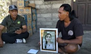 Ket poto: Suami korban sedang memegang poto istrinya