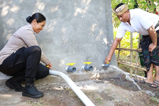 Ket poto: Kapolres Jembrana AKBP Kadek Citra Dewi Suparwati membuka kran pertama dalam peresmian sumur bor di Banjar Pancardawe