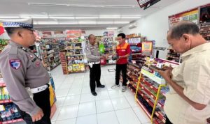Ket poto: Pegawai Alfamart menyerahkan dompet yang ditemukan di depan toko ke pada petugas kepolisian