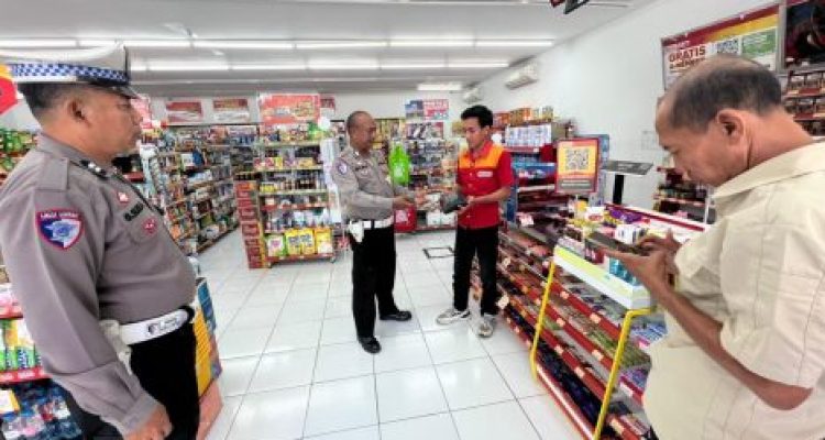 Ket poto: Pegawai Alfamart menyerahkan dompet yang ditemukan di depan toko ke pada petugas kepolisian
